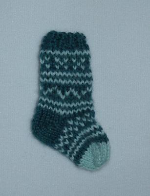 Miniature Sock - facing right
<p>I want to wear this as a pendant! It's so <strong>adorable</strong>...my American Girl doll was looking on in envy, but thank goodness, it wouldn't fit her, anyway! ;D</p>
Keywords: knitting