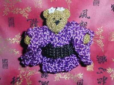 Mariko bear
This is Mariko bear.  She's crocheted out of three or four strands of metallic gold embroidery floss.  Her cape is rayon embroidery floss.  Her nose and flowers are made of 15/0 seed beads, beaded in peyote stitch, the nose in a heart shape.  She's fully jointed (arms, legs and head).
Keywords: crochet