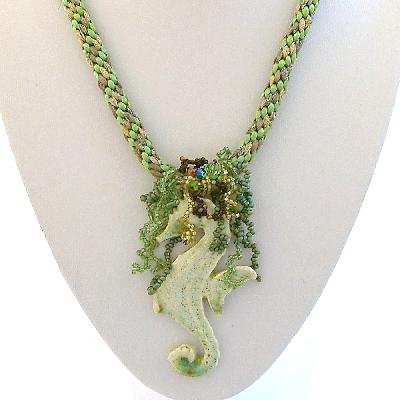 Green Ceramic Seahorse Kumihimo Pendant
<p>The seahorse is suspended from a mixed green kumihimo rope embellished with seed bead fringe 